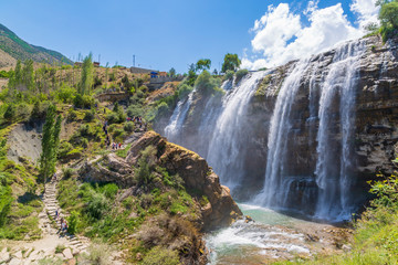 Fototapeta na wymiar Tortum (Uzundere) waterfall from the side with people in Uzundere, Erzurum, Turkey