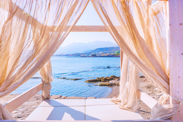 Fototapeta na wymiar Sea view through the curtains of a luxurious bed on the beach