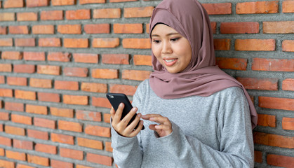 Naklejka premium close up young asian muslim woman holding smartphone for surf the net and watching media or shopping online , woman lifestyle concept