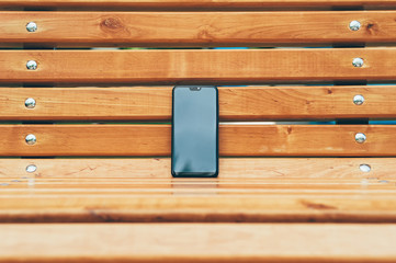 Mock Up smartphone, against the background of a wooden bench.