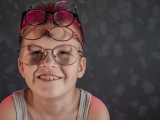 Fototapeta na wymiar Photo of funny kid with many pairs of glasses on face