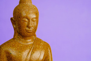 Buddha stone sculpture close-up purple background macro