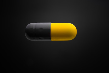 Floating or levitate black and yellow capsule pills in the thin air
