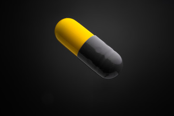 Floating or levitate black and yellow capsule pills in the thin air