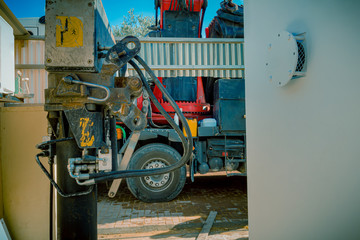 Fototapeta na wymiar Closeup of hydraulic pistons of a parking rigging truck with heavy lifting crane arm machine