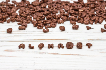 dry cereal breakfast laid out with the word alphabet on a white wooden background.