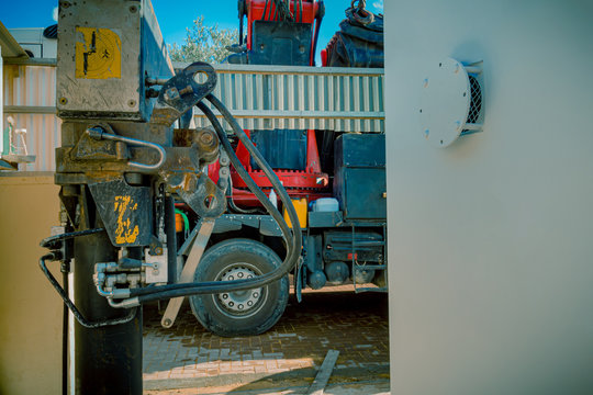 Closeup of hydraulic pistons of a parking rigging truck with heavy lifting crane arm machine