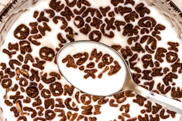 Dry cereal breakfast in a plate on a white wooden background.
