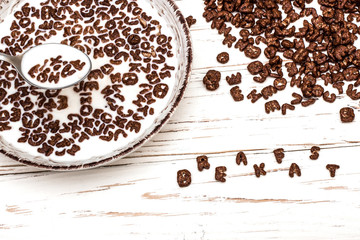 dry cereal breakfast laid out by the word breakfast on a white wooden background.