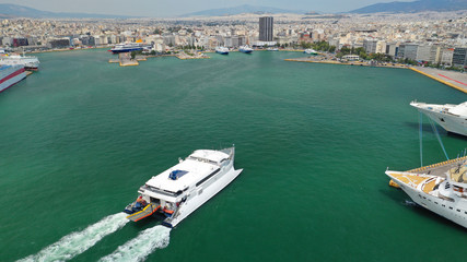 Aerial drone photo of high speed passenger catamaran ferry approaching in low speed iconic port of Piraeus, Attica, Greece