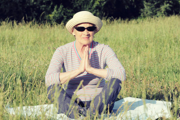 Portrait of an elderly woman on a sunny day.  Senior  practices yoga in the park