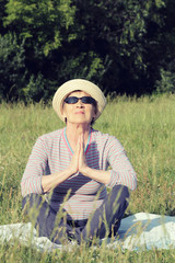 Portrait of an elderly woman on a sunny day.  Senior  practices yoga in the park
