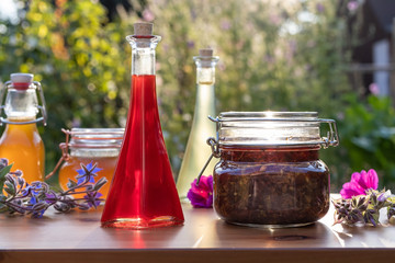 Bottles of homemade herbal oils and syrups in garden