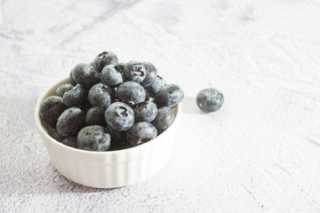 Blueberries with water drops on concrete background.