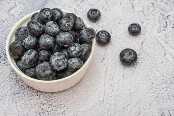 Blueberries with water drops on concrete background.