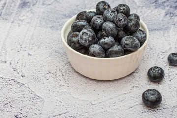 Blueberries with water drops on concrete background.