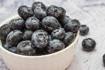 Blueberries with water drops on concrete background.