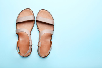 Female beige sandals on blue background