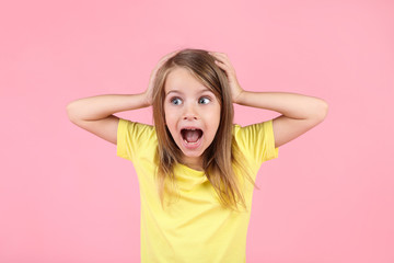 Emotional little girl on pink background