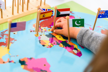 Girl placing flags of Europe and Spain on a map © Road Red Runner