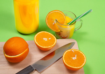 glass of fresh orange juice with fresh fruits on green background