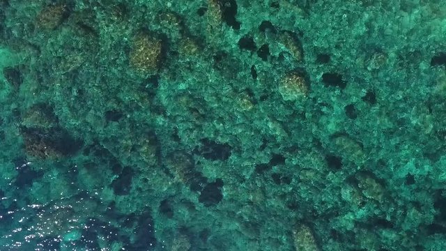 Top view of the big rocks in turquoise sea