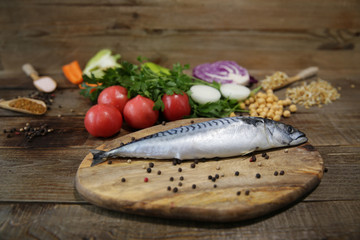 Fresh mackerel isolated on a wooden cutting board with vegetables, sprouted beans and herbs and spices. Health concept. Mediterranean diet. Ketogenic Keto diet. Atkins diet. Copy space for text. 