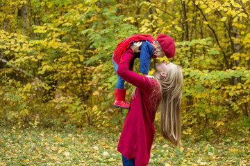 Mom hugs her daughter in an autumn park.