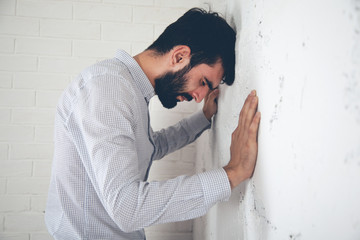 sad man in studio head on wall