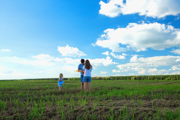 Family is flying a kite in a field