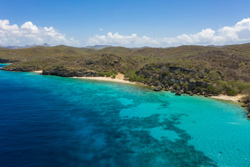 Fototapeta na wymiar Aerial view of coast of Curaçao in the Caribbean Sea with turquoise water, white sandy beach and beautiful coral reef at Playa Manzalina 