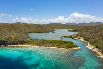 Aerial view of coast of Curaçao in the  Caribbean Sea with turquoise water, white sandy beach and beautiful coral reef at Playa Manzalina 