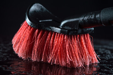 red car wash brush with a soft black handle on a black background