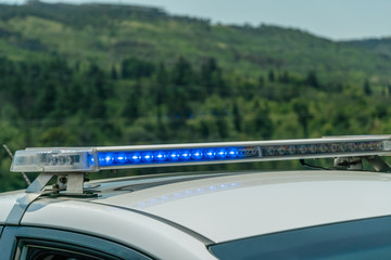 Police are blinking the lights of the car roof in the open air against the backdrop of the...