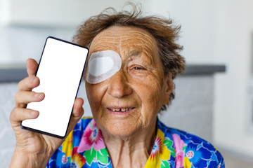 bandage on eye of a senior person - obrazy, fototapety, plakaty