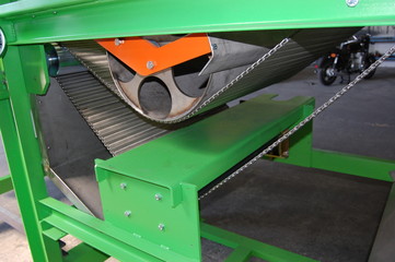 a fragment of an industrial machine with a steel wire belt conveyor and a stainless steel tray