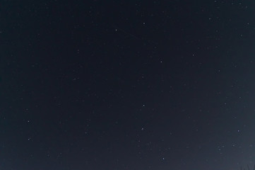 Naklejka na ściany i meble Night sky low light photo. A lot of stars and constellations on dark sky. Stock photo of deep sky. Far away from city and no clouds.