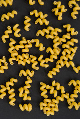 Spaghetti spirals on a black background. Top Viev. Horizontal photo.