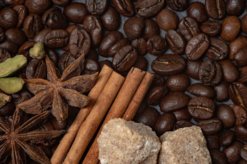 Composition of coffee and cane sugar on a stone background with the addition of anise, cinnamon and cane sugar.