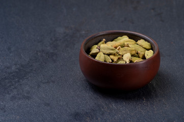 Cardamom in ceramic cup on stone background