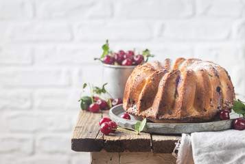 Fresh homemade bundt cake with cherry on wooden table