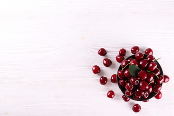 Bunch of fresh organic sweet cherries on textured background. Clean eating concept. Healthy nutritious vegan snack, raw diet. Close up, copy space, top view, flat lay.