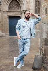 Obraz premium Handsome adult man with a beard in a jeans jacket