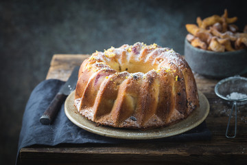 Rustic Style Apple Bundt Cake Sprinkled with Icing Sugar on old wooden table