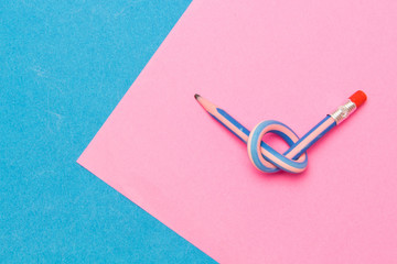 Flexible pencil . The concept of Binding business. Bent pencils two-color on background .