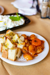 Greek food, cooked white beans with carrot and tomatoes served with roasted with olive oil and herbs bread