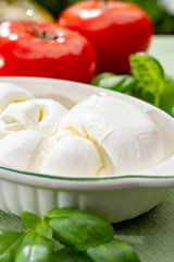 Twisted to form a plait treccia mozzarella Italian soft cheese served with fresh basil and tomatoes