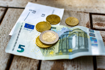 Bill or receipt payment in outdoor cafe in Euro cash, banknote and coins close up