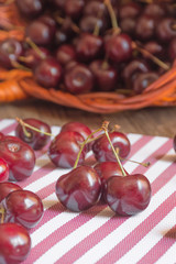Close up of organic fresh sweet cherries in the basket, farm fruits on farmer market table. Healthy food consept