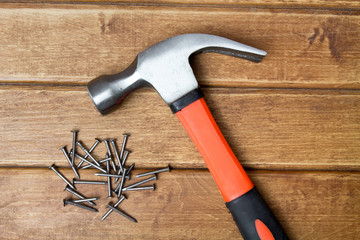 Hammer and nails scattered on wooden background. Joinery concept